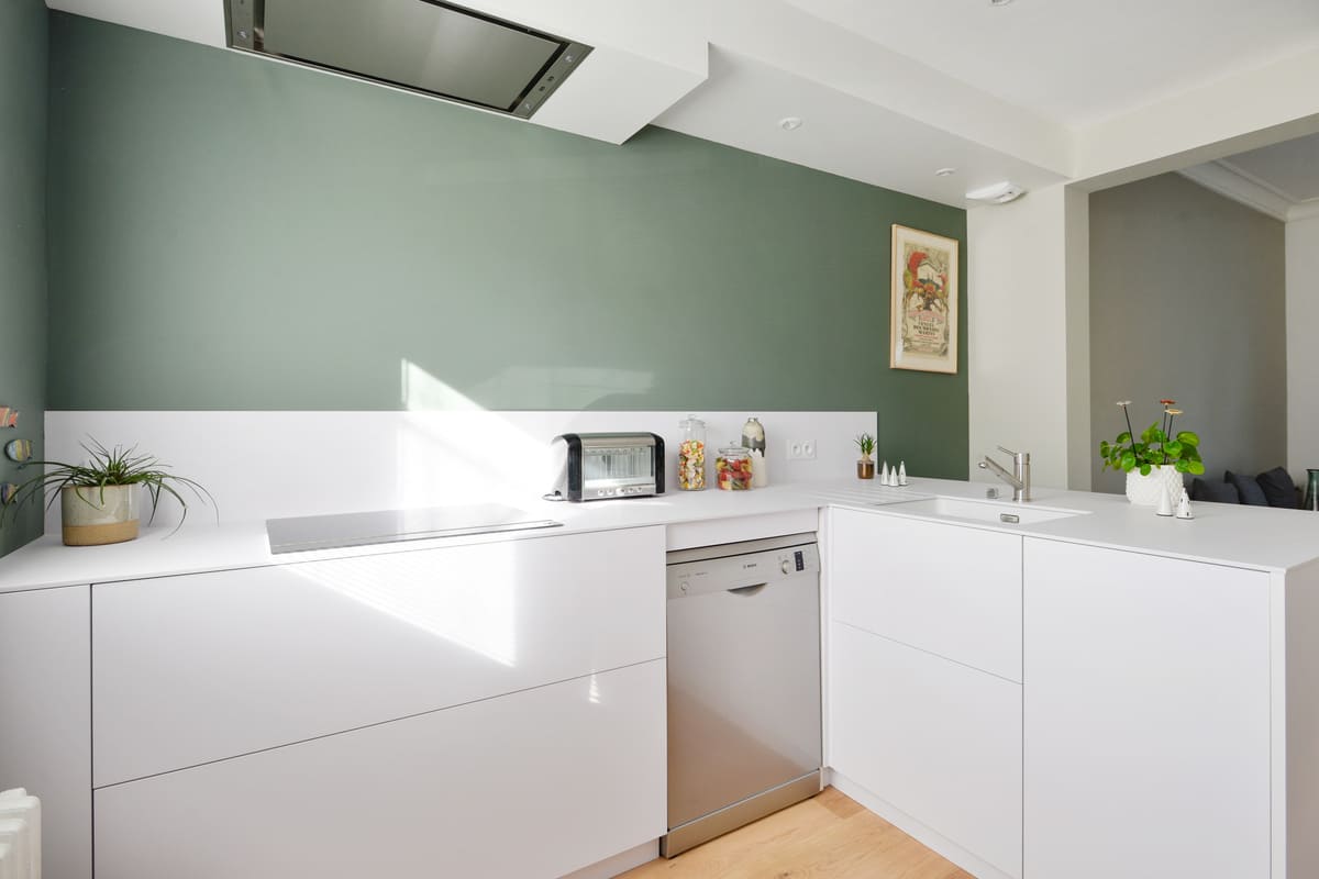 Cuisine moderne blanche avec mur vert émeraude à Nantes | Raison Home